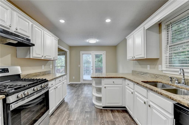 1400 Scenic Brook Trl SW, Conyers, GA 30094 - kitchen with stainless steel range with gas stovetop, a sink, under cabinet range hood, white cabinets, and recessed lighting