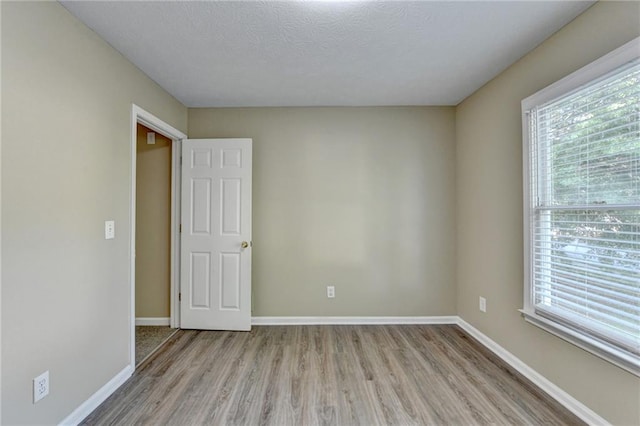 1400 Scenic Brook Trl SW, Conyers, GA 30094 - empty room with light wood-style floors, baseboards, and a textured ceiling