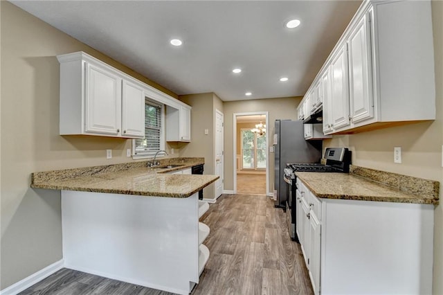 1400 Scenic Brook Trl SW, Conyers, GA 30094 - kitchen with stainless steel range with gas stovetop, a sink, baseboards, white cabinets, and recessed lighting