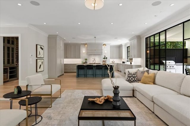 living room featuring light hardwood / wood-style flooring and crown molding