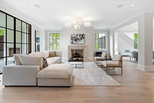 living room with crown molding and light hardwood / wood-style floors