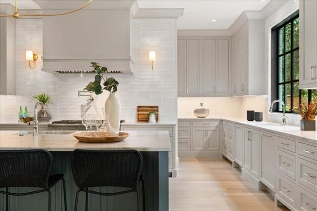 kitchen featuring light stone countertops, a kitchen breakfast bar, and decorative backsplash