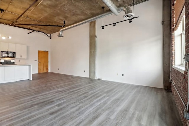 unfurnished living room with hardwood / wood-style flooring and a high ceiling