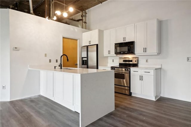 kitchen with sink, a high ceiling, white cabinets, and appliances with stainless steel finishes
