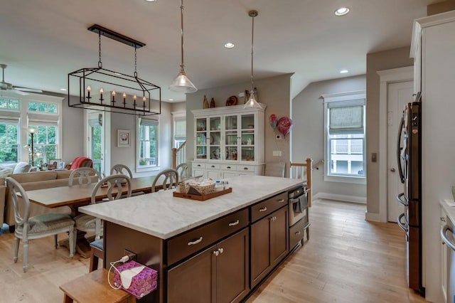 kitchen featuring a center island, plenty of natural light, decorative light fixtures, and light hardwood / wood-style flooring