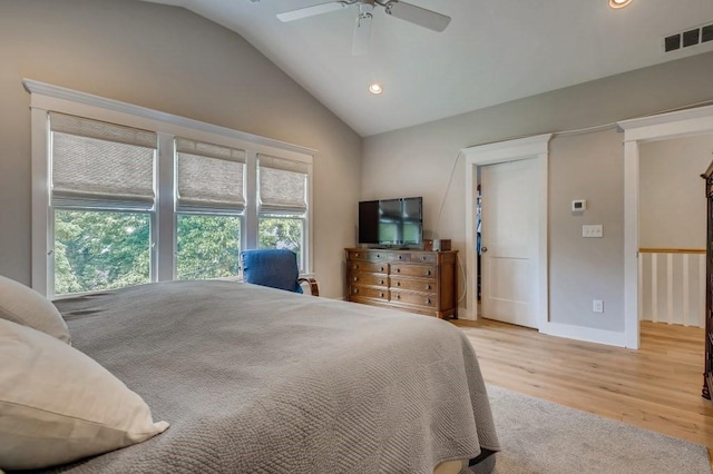 bedroom with ceiling fan, light hardwood / wood-style floors, and vaulted ceiling