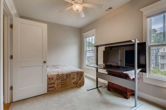 carpeted bedroom featuring ceiling fan and multiple windows