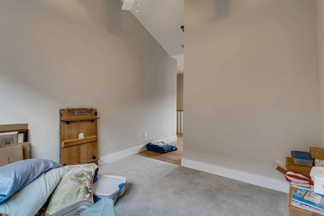 bedroom featuring light carpet and high vaulted ceiling