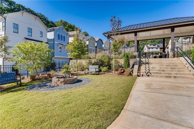 surrounding community featuring a fire pit and a yard