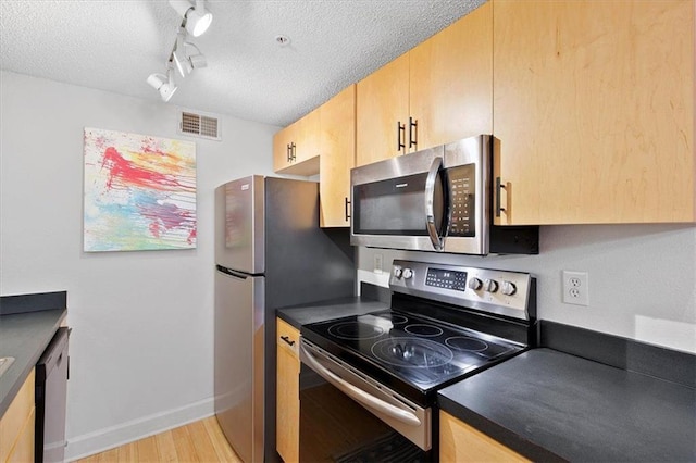 387 Ralph Mcgill Blvd NE Unit K, Atlanta, GA 30312 - kitchen with stainless steel appliances, light brown cabinets, a textured ceiling, and dark countertops