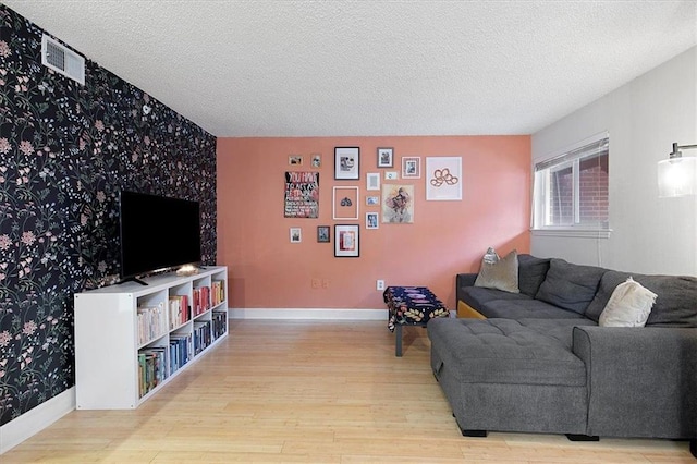 387 Ralph Mcgill Blvd NE Unit K, Atlanta, GA 30312 - living room featuring wallpapered walls, an accent wall, wood finished floors, a textured ceiling, and baseboards