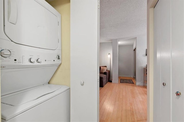 387 Ralph Mcgill Blvd NE Unit K, Atlanta, GA 30312 - washroom featuring stacked washing machine and dryer, light wood finished floors, baseboards, and a textured ceiling