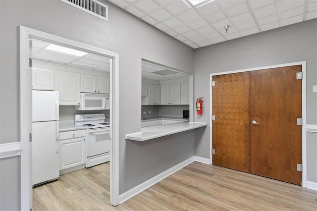387 Ralph Mcgill Blvd NE Unit K, Atlanta, GA 30312 - kitchen featuring white appliances, light wood-style floors, light countertops, white cabinets, and a paneled ceiling