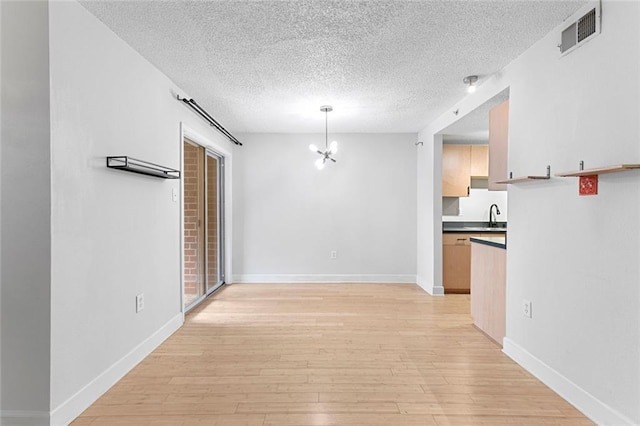 387 Ralph Mcgill Blvd NE Unit K, Atlanta, GA 30312 - unfurnished dining area featuring a textured ceiling, a chandelier, light wood-style flooring, and baseboards