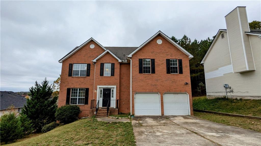 view of front of property with brick siding, concrete driveway, and a garage