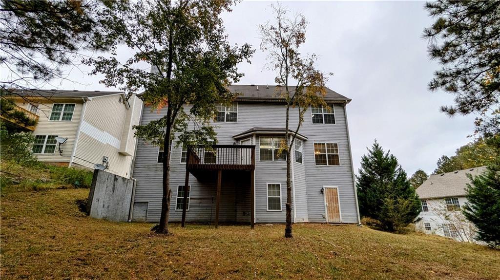 rear view of house with a deck and a yard