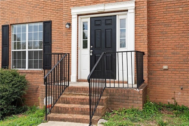 view of exterior entry featuring brick siding