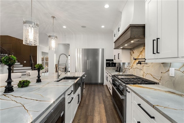 kitchen with stainless steel appliances, decorative light fixtures, white cabinetry, and light stone countertops