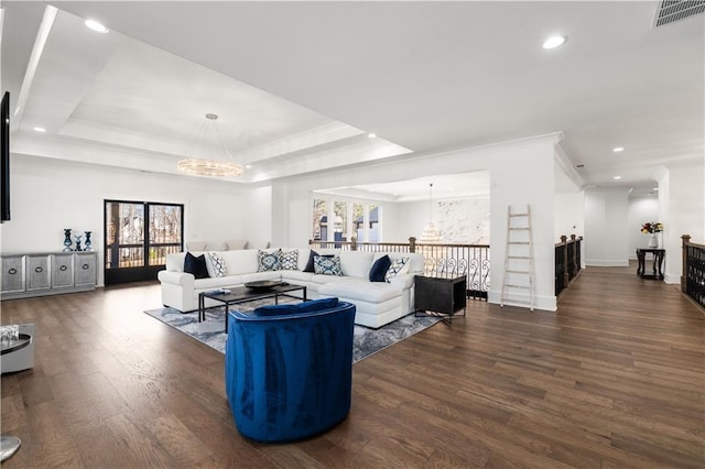 living room with crown molding, a raised ceiling, a notable chandelier, and dark hardwood / wood-style floors