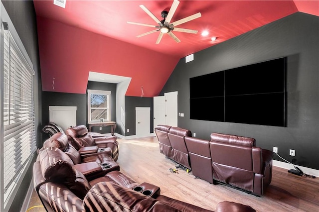 home theater with a healthy amount of sunlight, ceiling fan, vaulted ceiling, and light hardwood / wood-style flooring