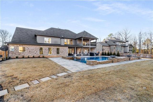 exterior space featuring a yard, a patio area, and a pool with hot tub