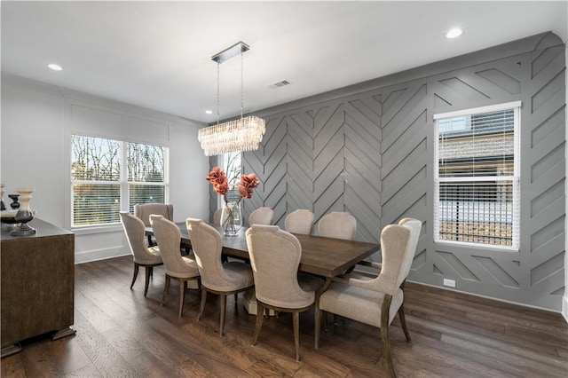 dining space with a healthy amount of sunlight, dark hardwood / wood-style floors, and a notable chandelier