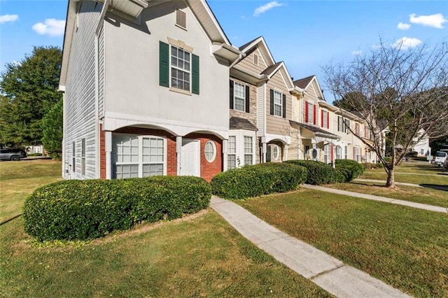 townhome / multi-family property featuring a front lawn