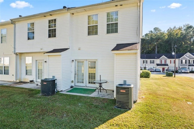 rear view of property featuring a patio area, a yard, and central AC unit