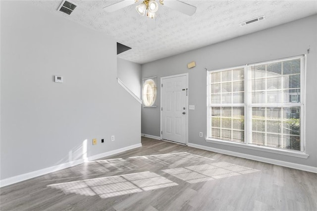 entrance foyer with light hardwood / wood-style flooring, a textured ceiling, and ceiling fan