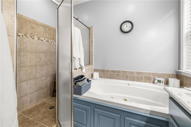 full bathroom featuring a whirlpool tub, a shower stall, and vanity