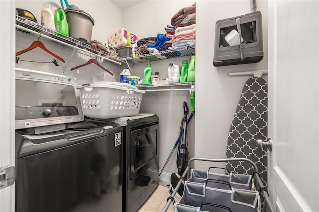 clothes washing area with separate washer and dryer, laundry area, and tile patterned floors