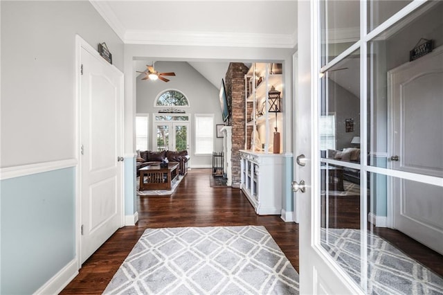 foyer featuring ornamental molding, wood finished floors, lofted ceiling, baseboards, and ceiling fan
