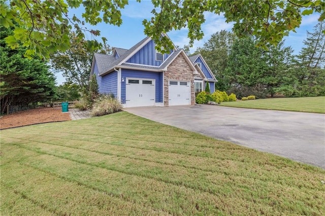 view of side of property with an attached garage, stone siding, board and batten siding, a lawn, and driveway