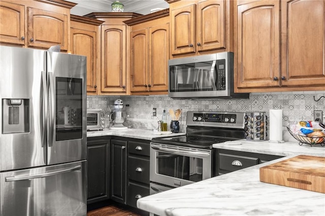 kitchen with backsplash, crown molding, a toaster, light stone counters, and stainless steel appliances