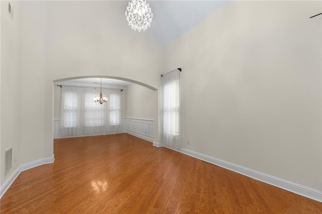 empty room featuring hardwood / wood-style floors and a notable chandelier