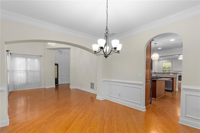 unfurnished dining area featuring light hardwood / wood-style floors, sink, crown molding, and ceiling fan with notable chandelier