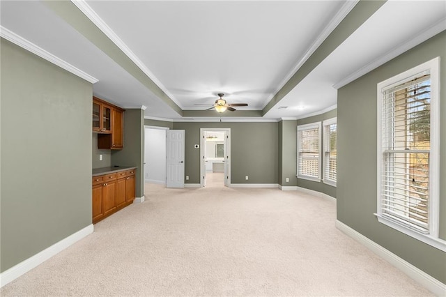 carpeted living room with ceiling fan, ornamental molding, and a raised ceiling