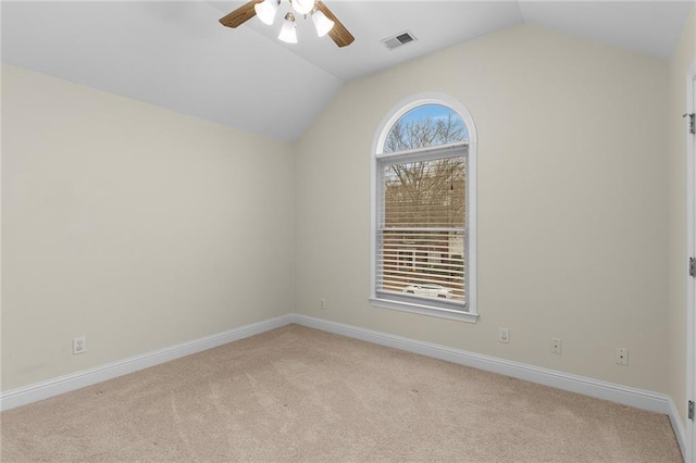 carpeted spare room featuring ceiling fan and vaulted ceiling