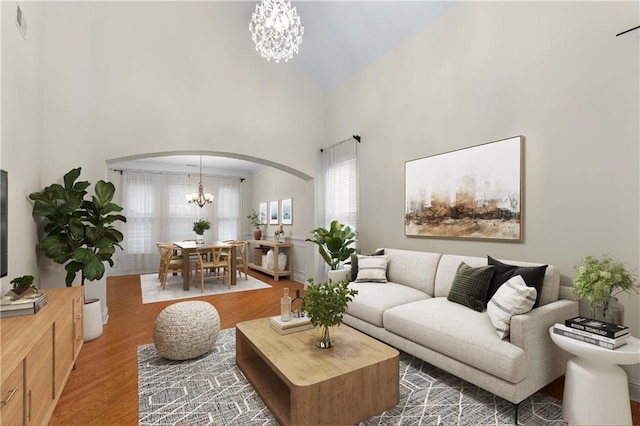 living room featuring a high ceiling, hardwood / wood-style floors, and an inviting chandelier