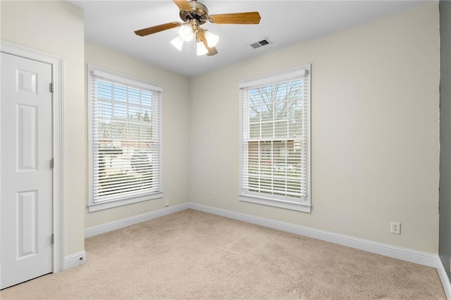 carpeted spare room featuring ceiling fan