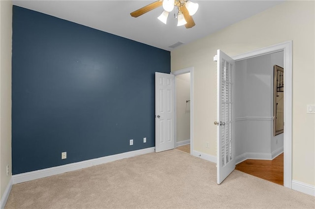 unfurnished bedroom with ceiling fan and light carpet