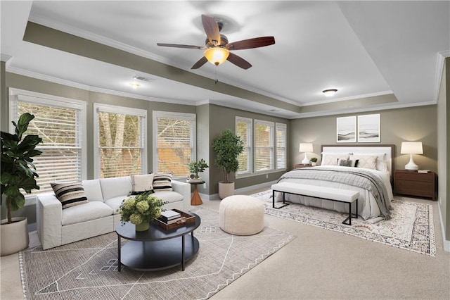 carpeted bedroom featuring ceiling fan, ornamental molding, and a tray ceiling