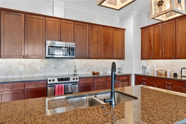 360 Chambers St Unit 402, Woodstock, GA 30188 - kitchen with stainless steel appliances, dark stone counters, tasteful backsplash, crown molding, and brown cabinets