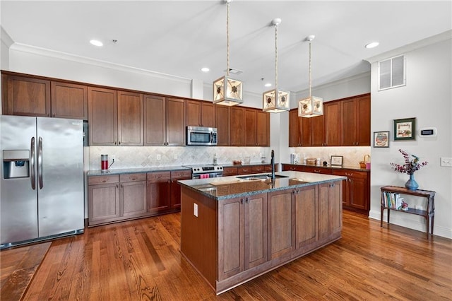 360 Chambers St Unit 402, Woodstock, GA 30188 - kitchen featuring appliances with stainless steel finishes, dark wood finished floors, an island with sink, backsplash, and dark stone counters