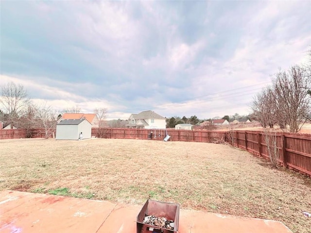 view of yard featuring a patio, a fire pit, and a shed