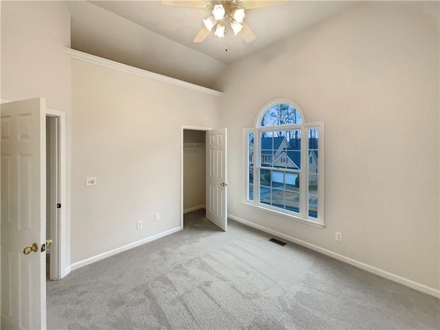 unfurnished bedroom featuring carpet, visible vents, baseboards, high vaulted ceiling, and a closet