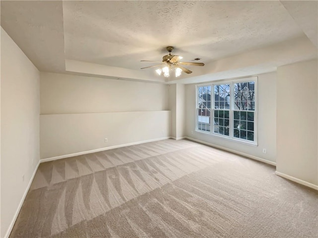 unfurnished room featuring a textured ceiling, carpet, and baseboards