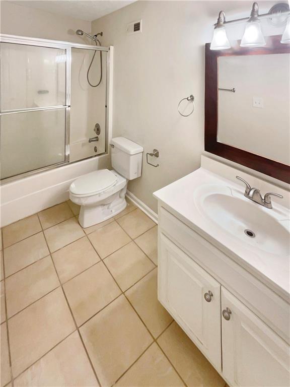 full bathroom with vanity, visible vents, enclosed tub / shower combo, tile patterned floors, and toilet