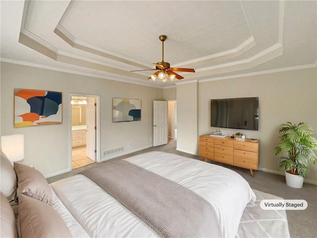 bedroom featuring light carpet, visible vents, baseboards, and a tray ceiling