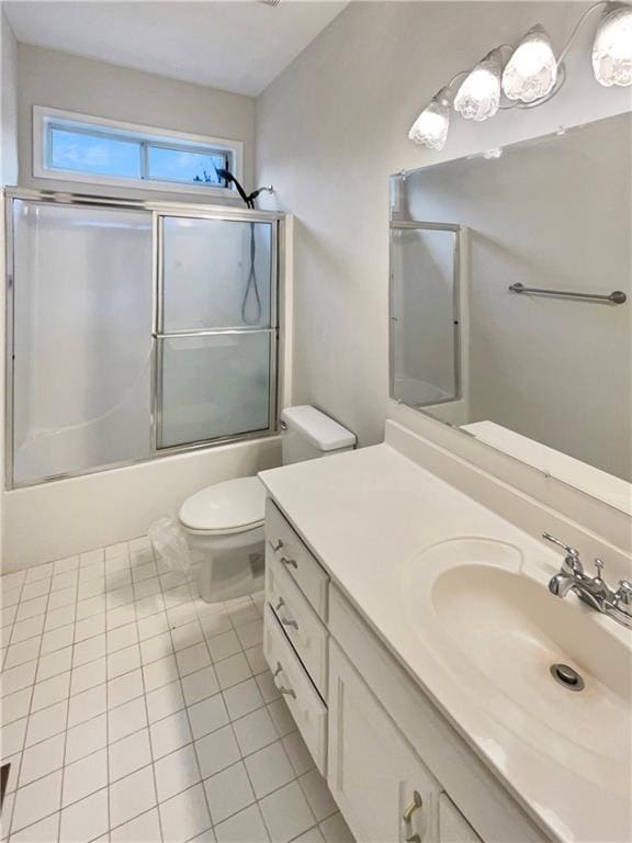 full bathroom with tile patterned flooring, combined bath / shower with glass door, toilet, and vanity